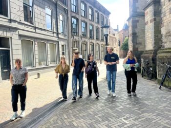 Foto van de deelnemers van het herfstlab 2025. 6 mensen lopen in een rijtje over straat.